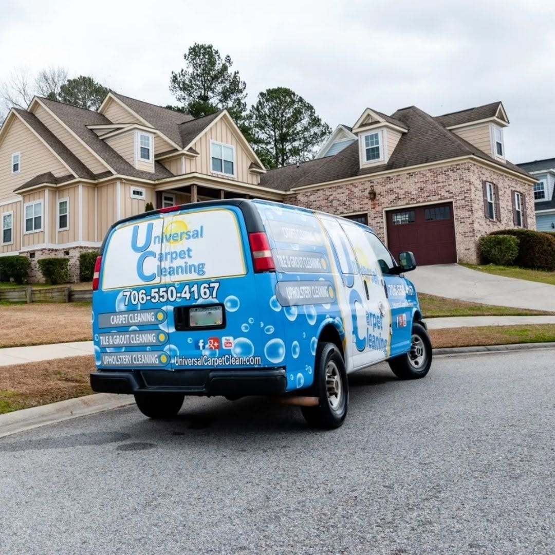 Universal Carpet Cleaning wrapped service van parked on a residential street