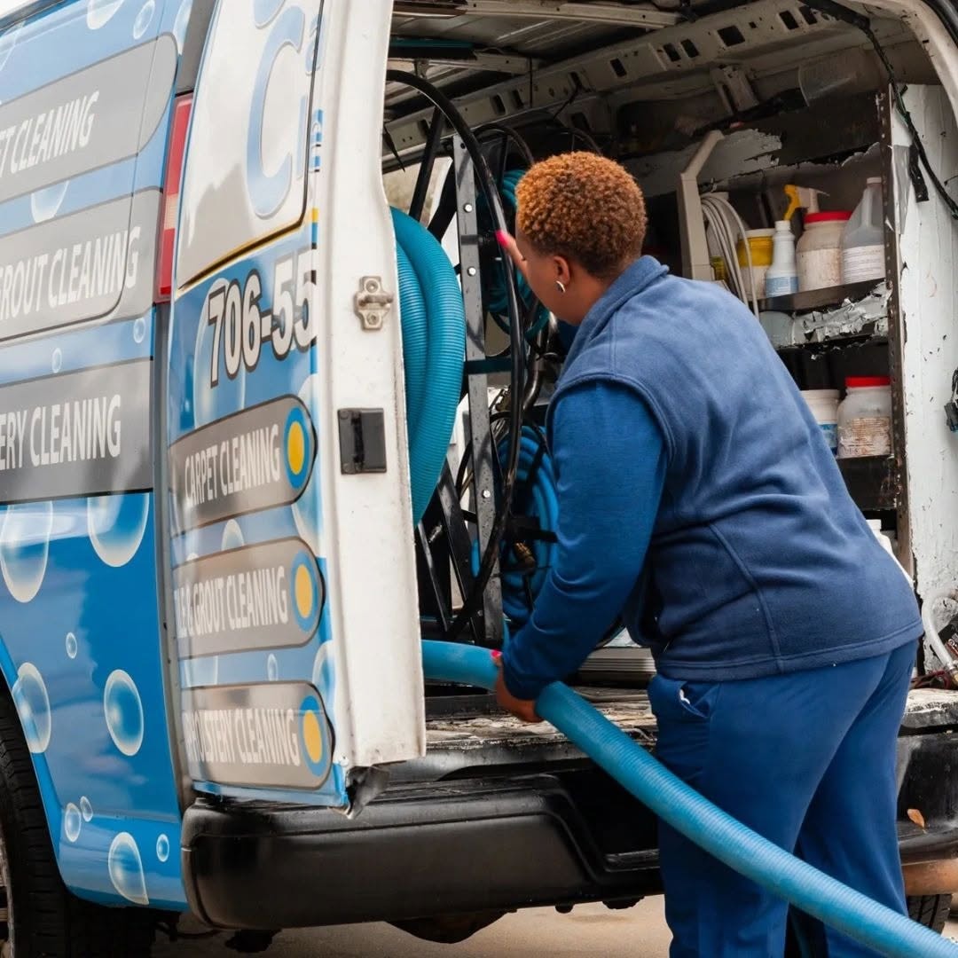 Technician loading equipment hose into the Universal Carpet Cleaning van
